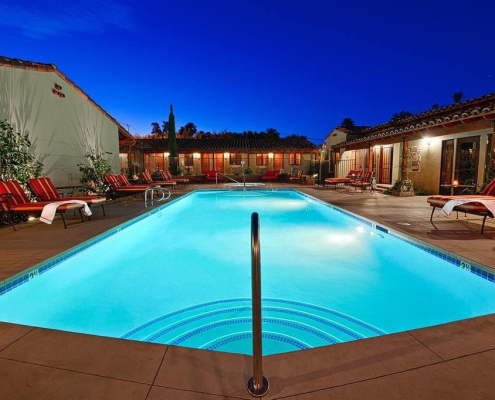 The courtyard pool at Los Arboles Hotel is illuminated at night