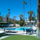 The pool at Iron Tree Inn surrounded by lounge chairs and palm trees