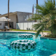 Green and white checkerboard inner tubes float on the water in the pool at The Monkey Tree Hotel in Palm Springs, California