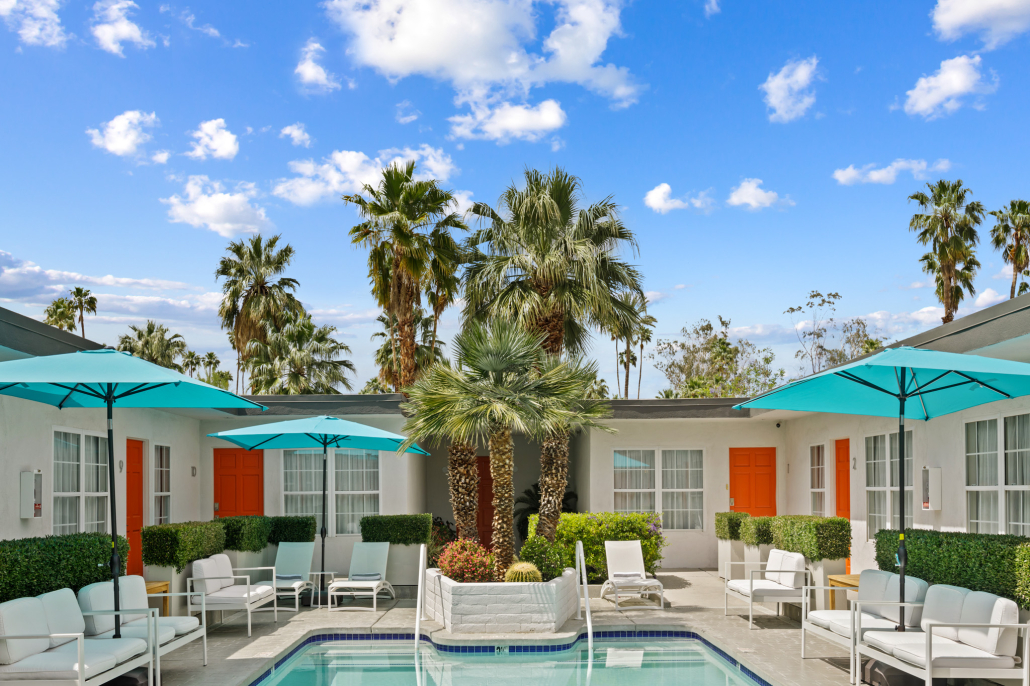 Puffy white clouds fill the blue sky above the courtyard pool at The Weekend Palm Springs