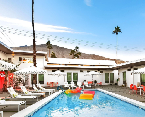 Two colorful rafts float in the courtyard pool on a sunny day at The Wesley Palm Springs hotel