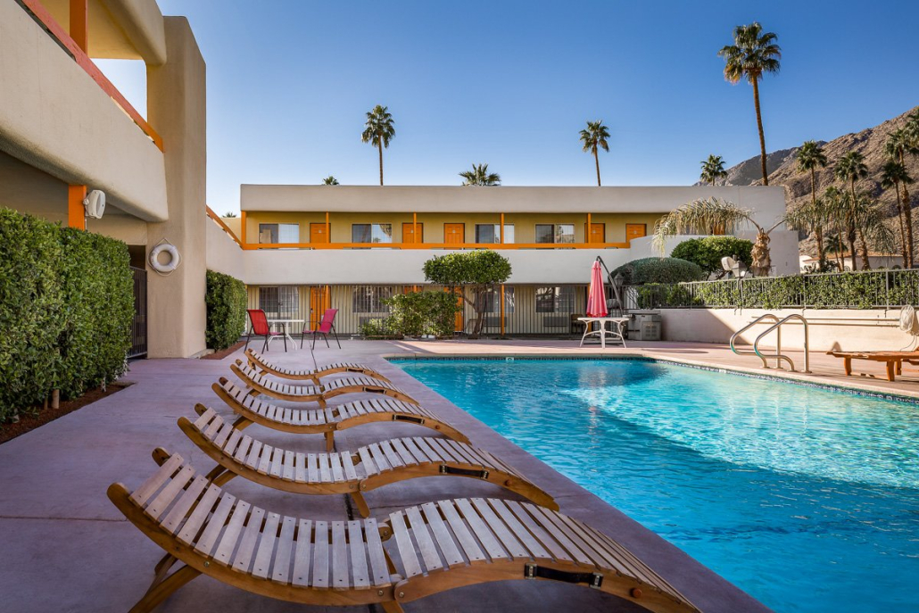 Wooden loungers line the large pool at Musicland Hotel in Palm Springs, California