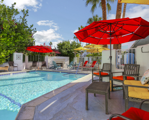 Red umbrellas provide shade next to the pool at the Inn at Palm Springs in Palm Springs, California