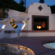 Two martini glasses on a table in front of a fireplace outside at the Hacienda at Warm Sands