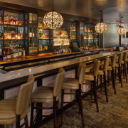 The long bar with leather seats lined up in front of it at Melvyn's Bar in the Ingleside Estate in Palm Springs