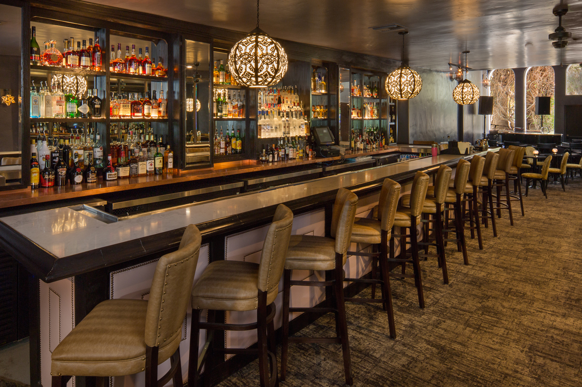 The long bar with leather seats lined up in front of it at Melvyn's Bar in the Ingleside Estate in Palm Springs