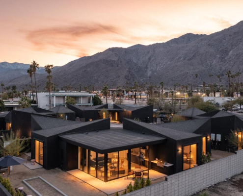 An aerial view of the four black buildings that make up Blackhaus with the San Jacinto Mountains in the background