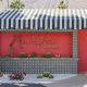 The front of The Muse Hotel Palm Springs is painted pink with a black and white striped awning