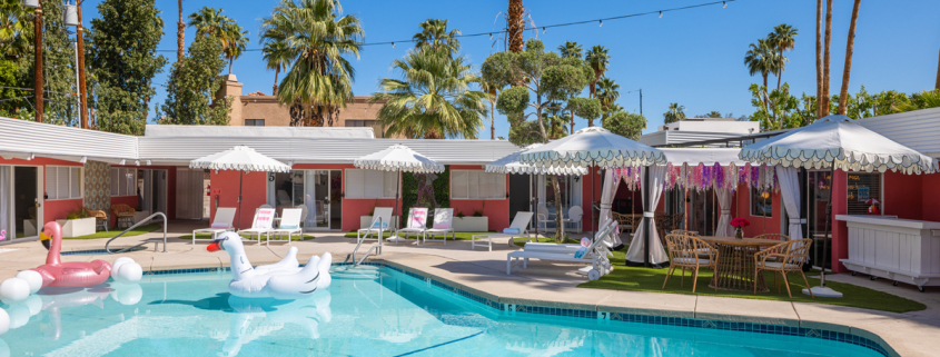 A white swan float in the pool at The Muse Palm Springs on a clear blue sky day