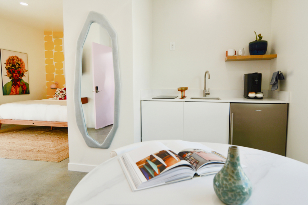 A kitchen at The Cactai in Palm Springs with a sink and white table with an open book on it