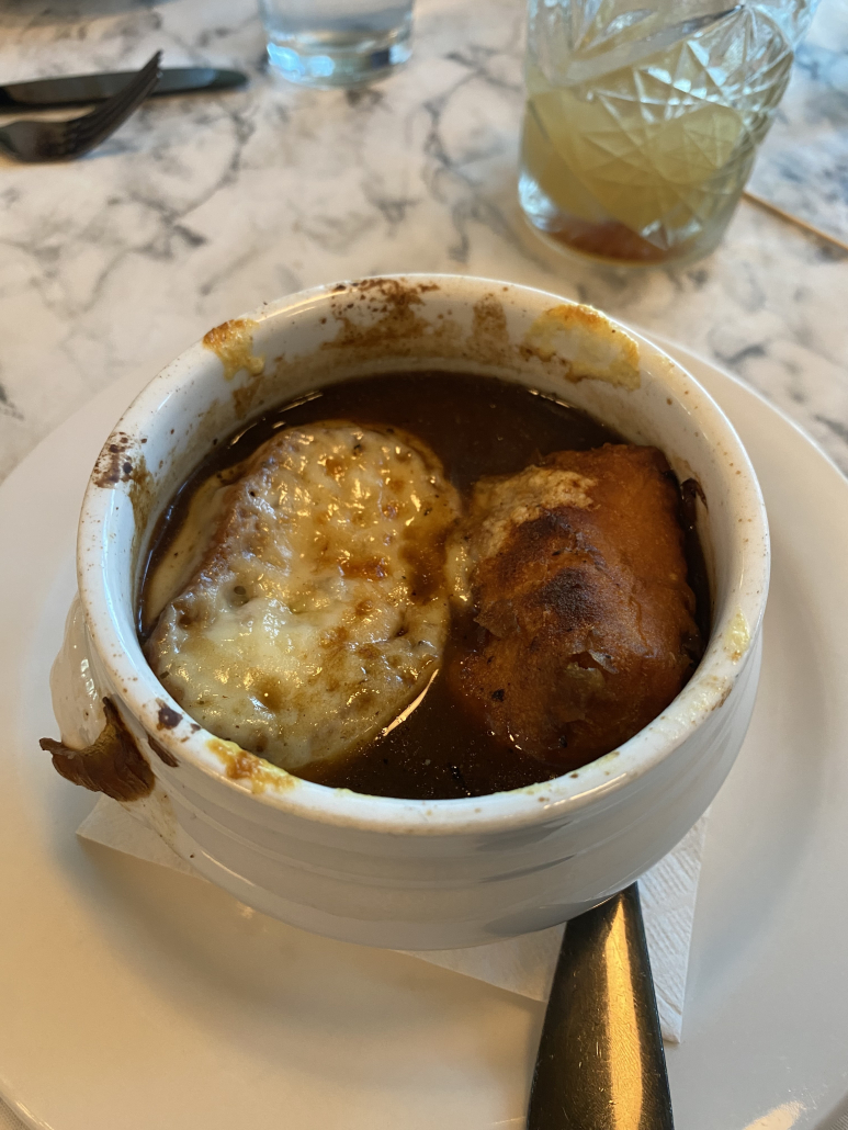 A bowl of French onion soup in a white crock from Freddie's Kitchen