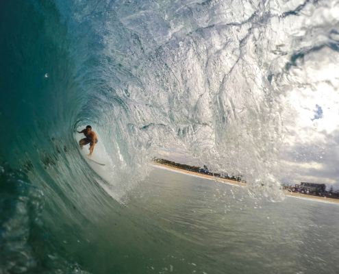 A person rides an ocean wave on a surfboard