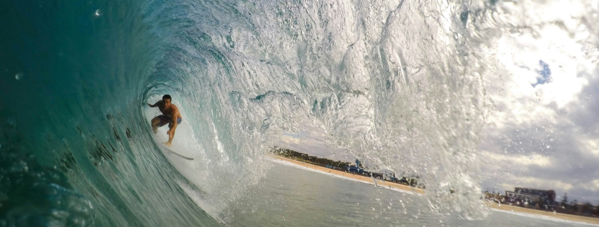 A person rides an ocean wave on a surfboard