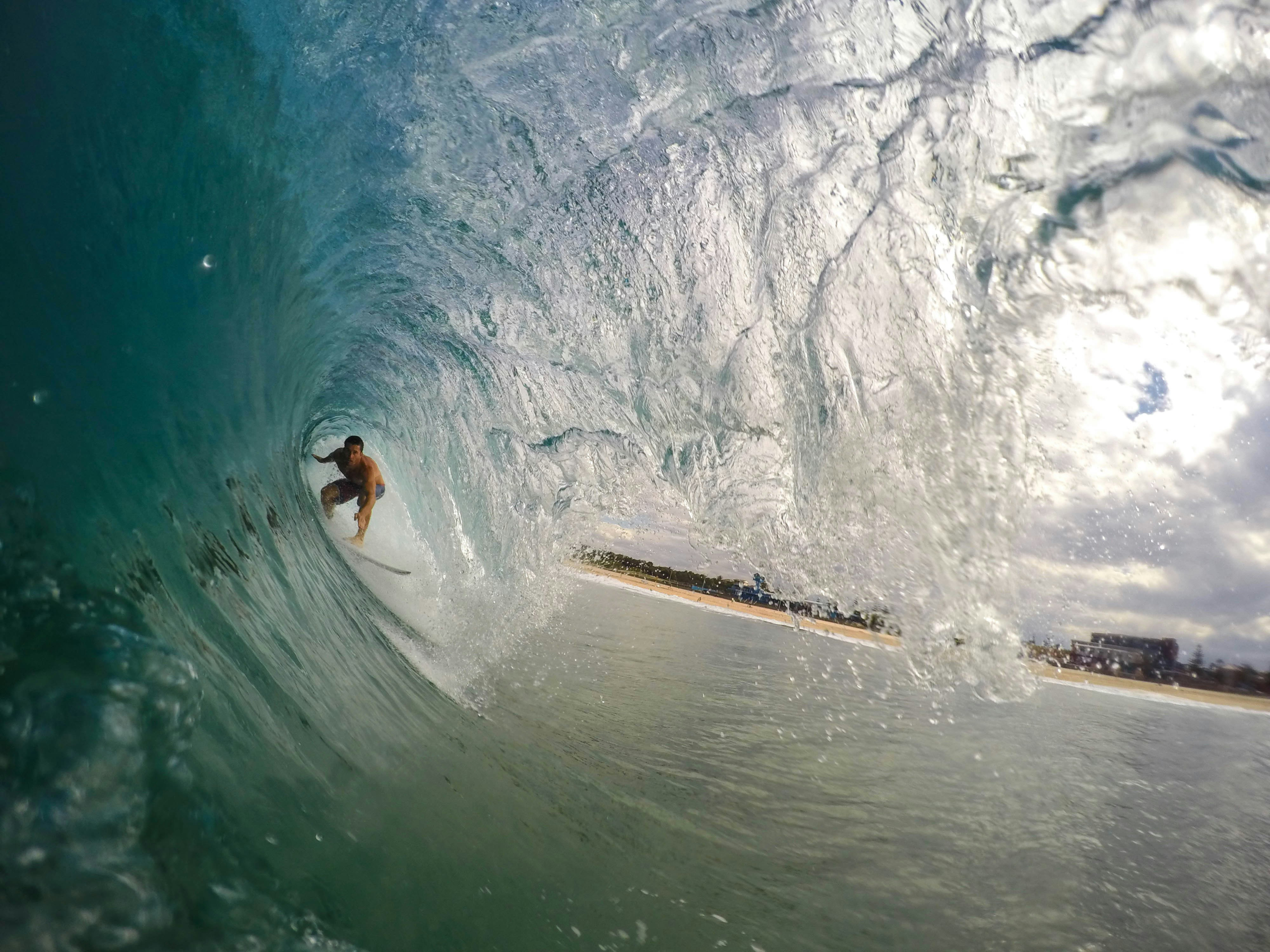 A person rides an ocean wave on a surfboard