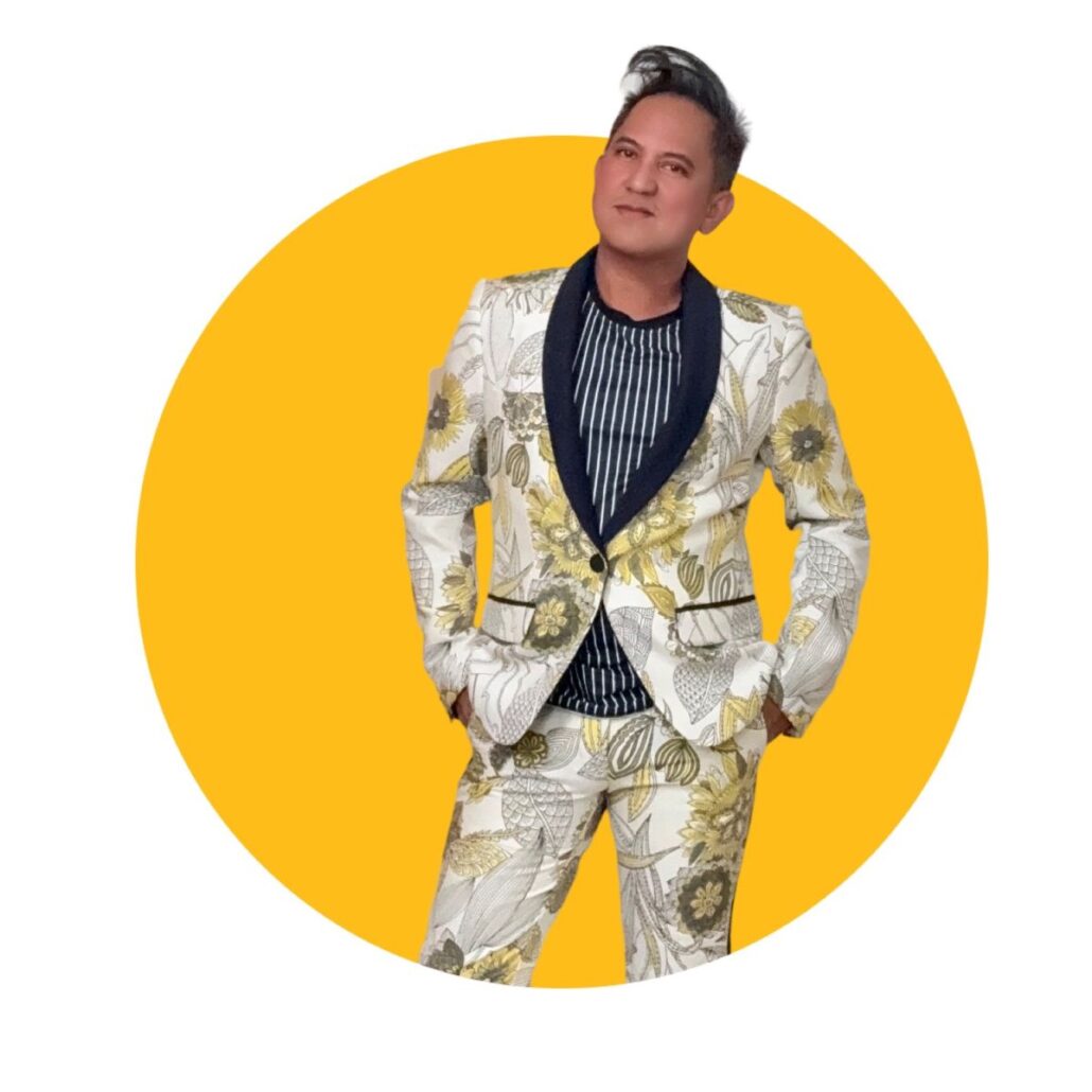 A man with black hair wears a patterned suit
