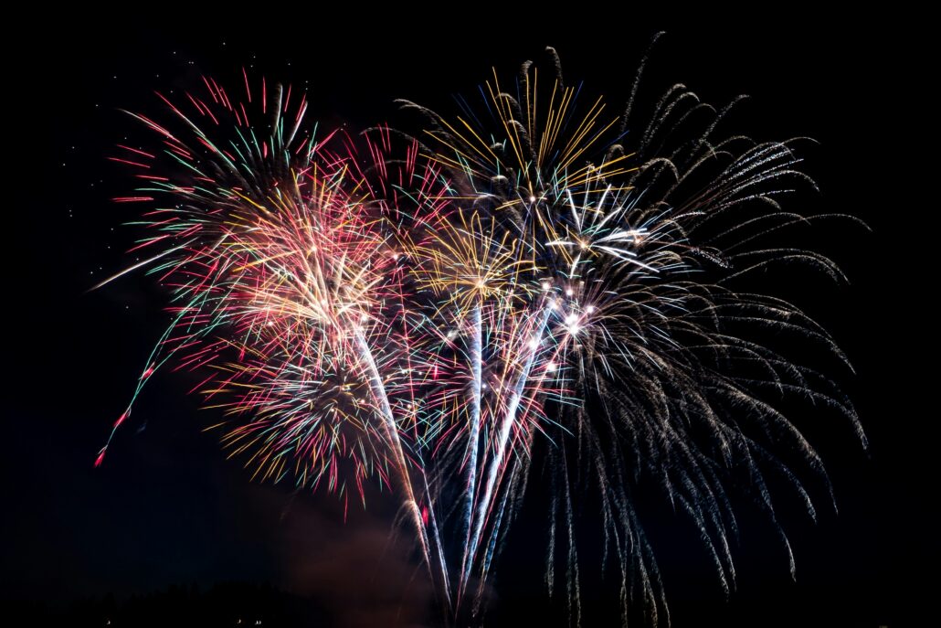 Fireworks explode in the sky. Photo by Elisha Terada on Unsplash