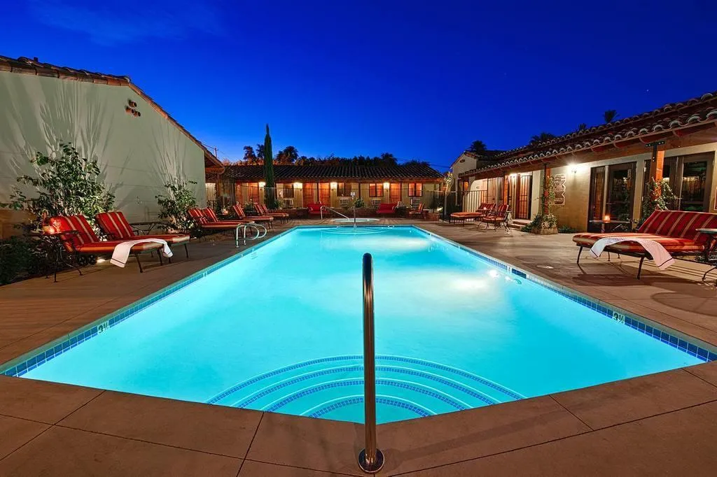 The courtyard pool at Los Arboles Hotel is illuminated at night