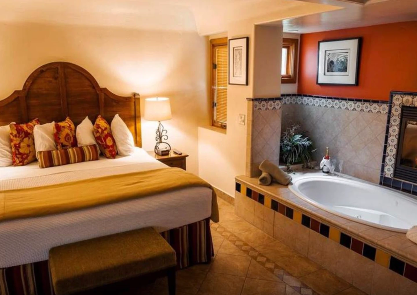 A bathtub is right next to the bed and fireplace in a Fireplace Room at Los Arboles Hotel in Palm Springs, California