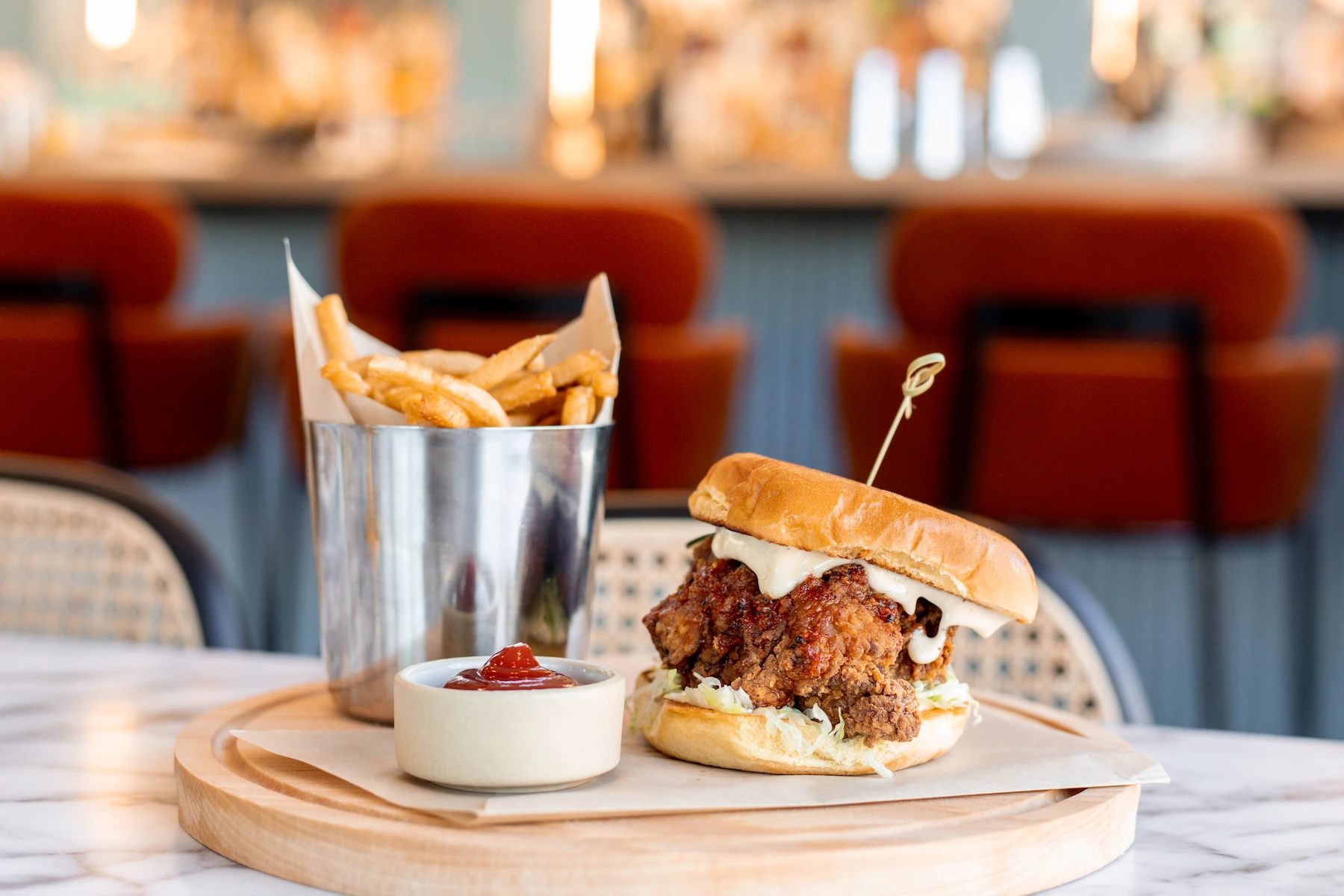 A fried chicken sandwich and French fries on a plate at Lost Property at The Skylark