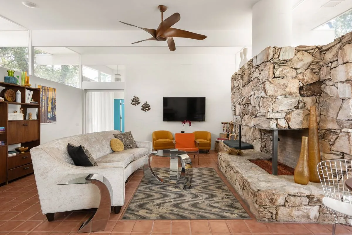 A rock fireplace in front of a white couch at The Monkey Tree Hotel in Palm Springs, California