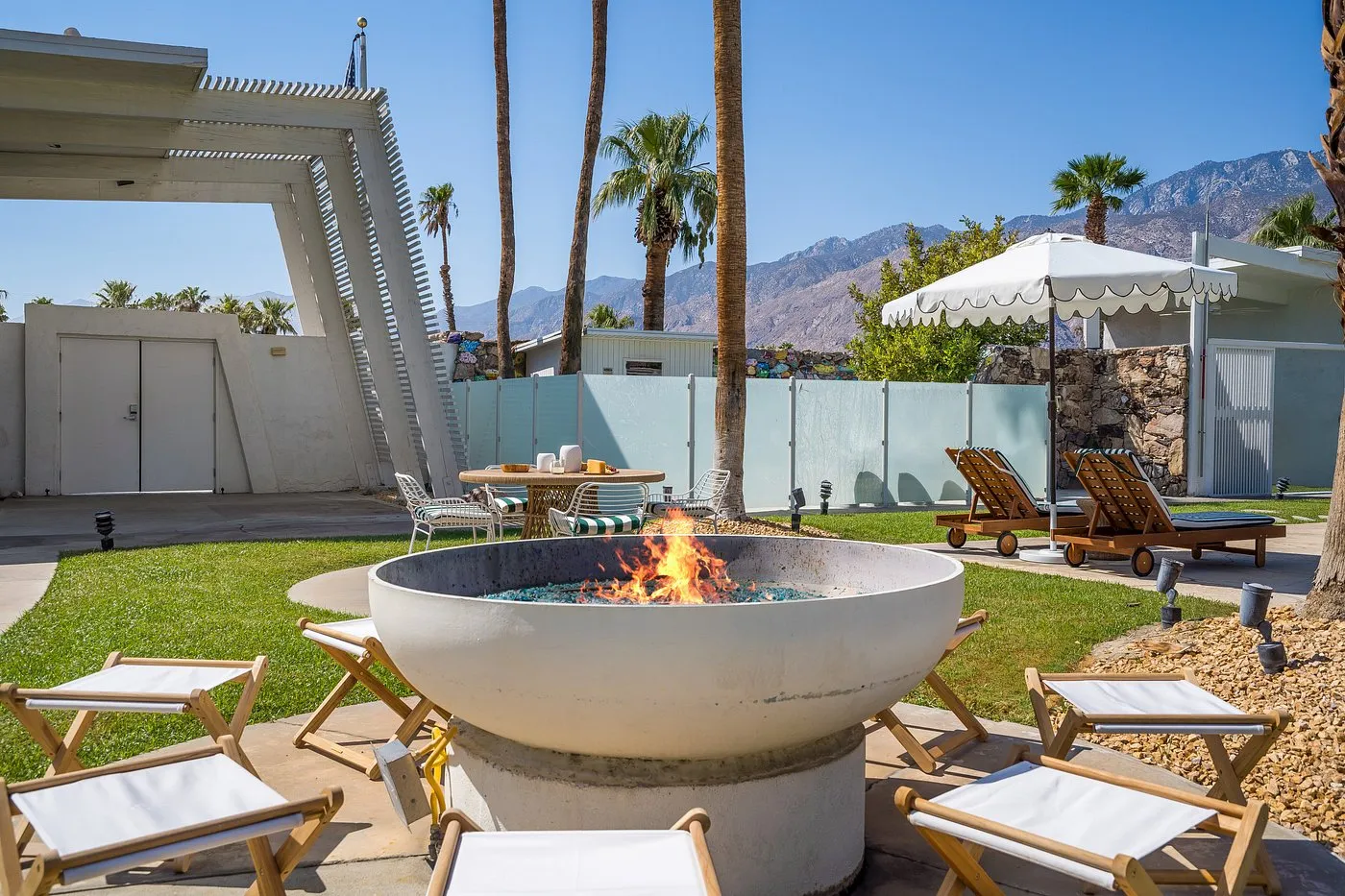 A large circular fire pit is turned on during the day at The Monkey Tree Hotel in Palm Springs, California