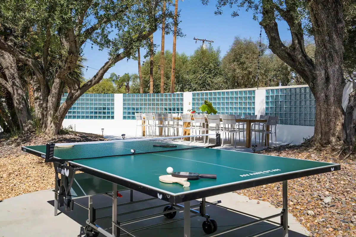 A dark green ping pong table outside on a cement slab at The Monkey Tree Hotel in Palm Springs, California