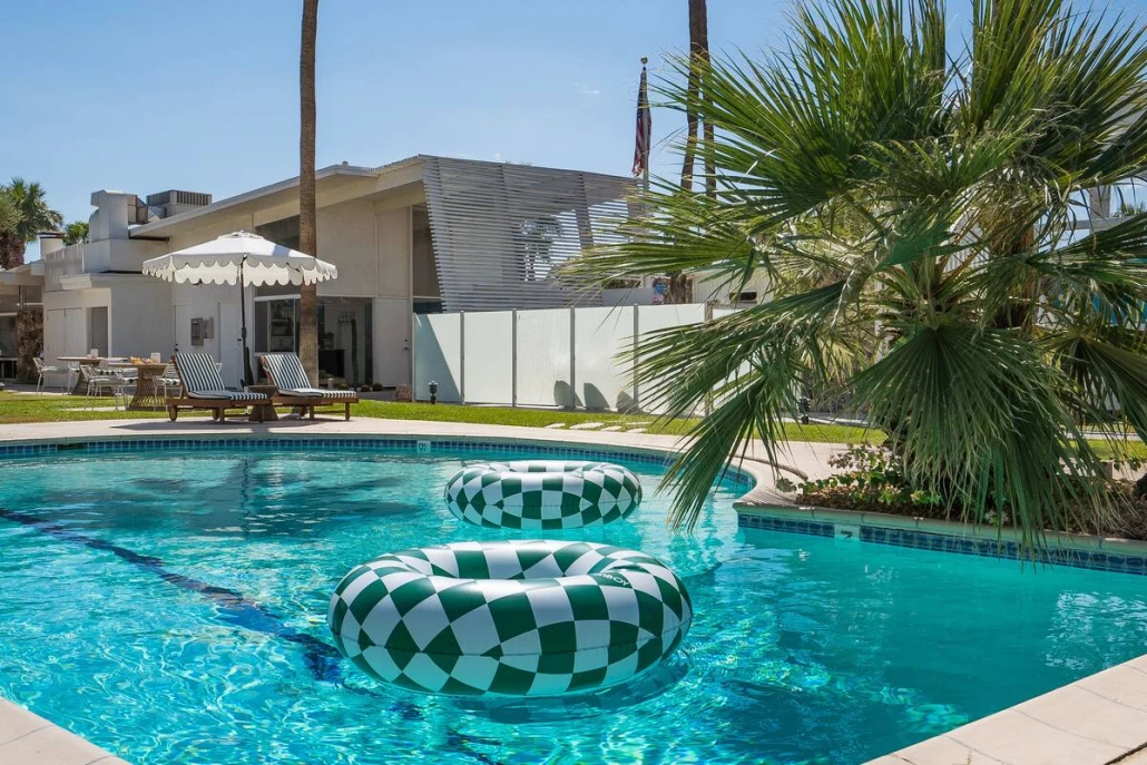 Green and white checkerboard inner tubes float on the water in the pool at The Monkey Tree Hotel in Palm Springs, California