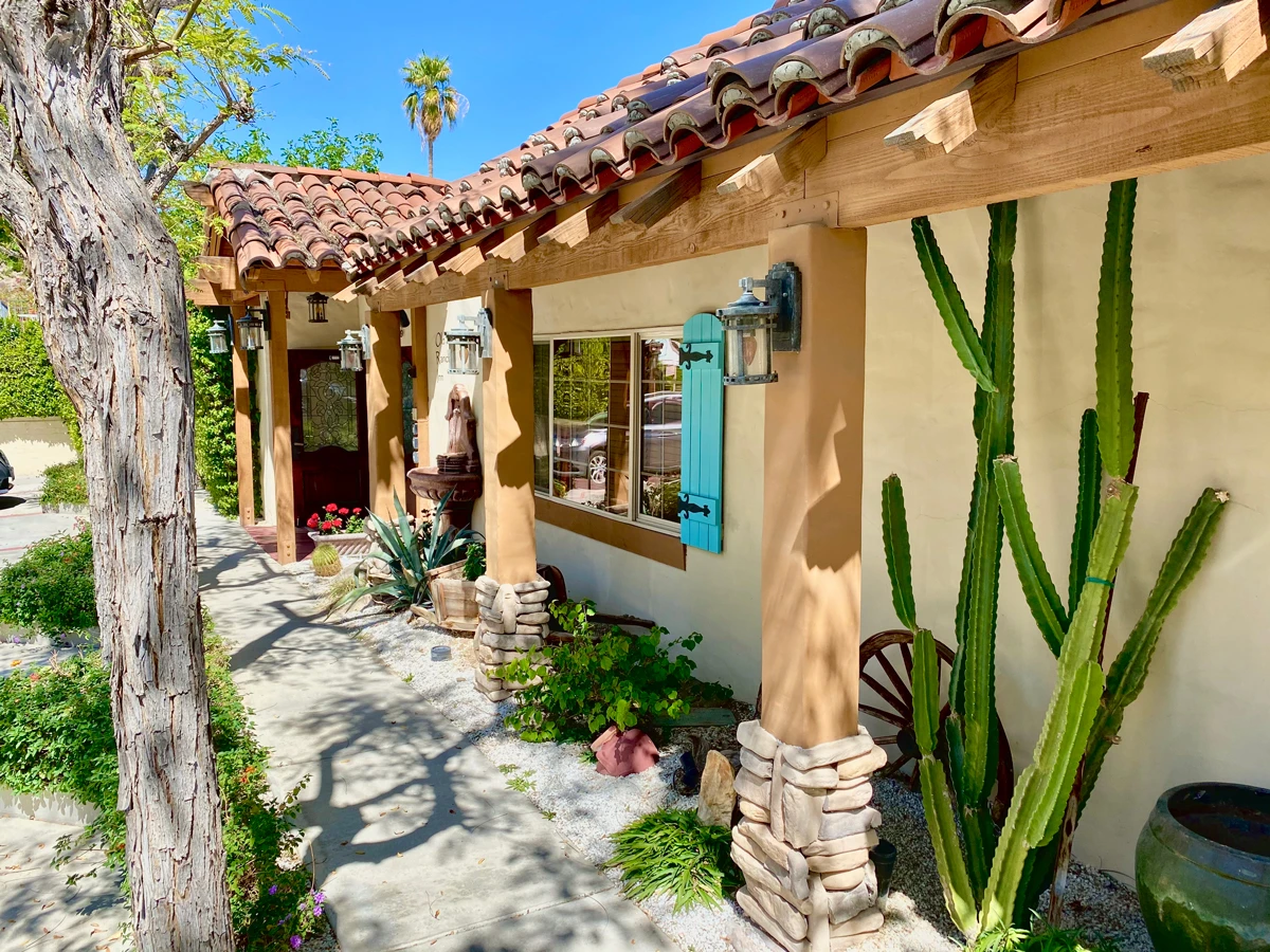 There are cacti and other greenery along the path that leads to the welcoming Old Ranch Inn in Palm Springs, California