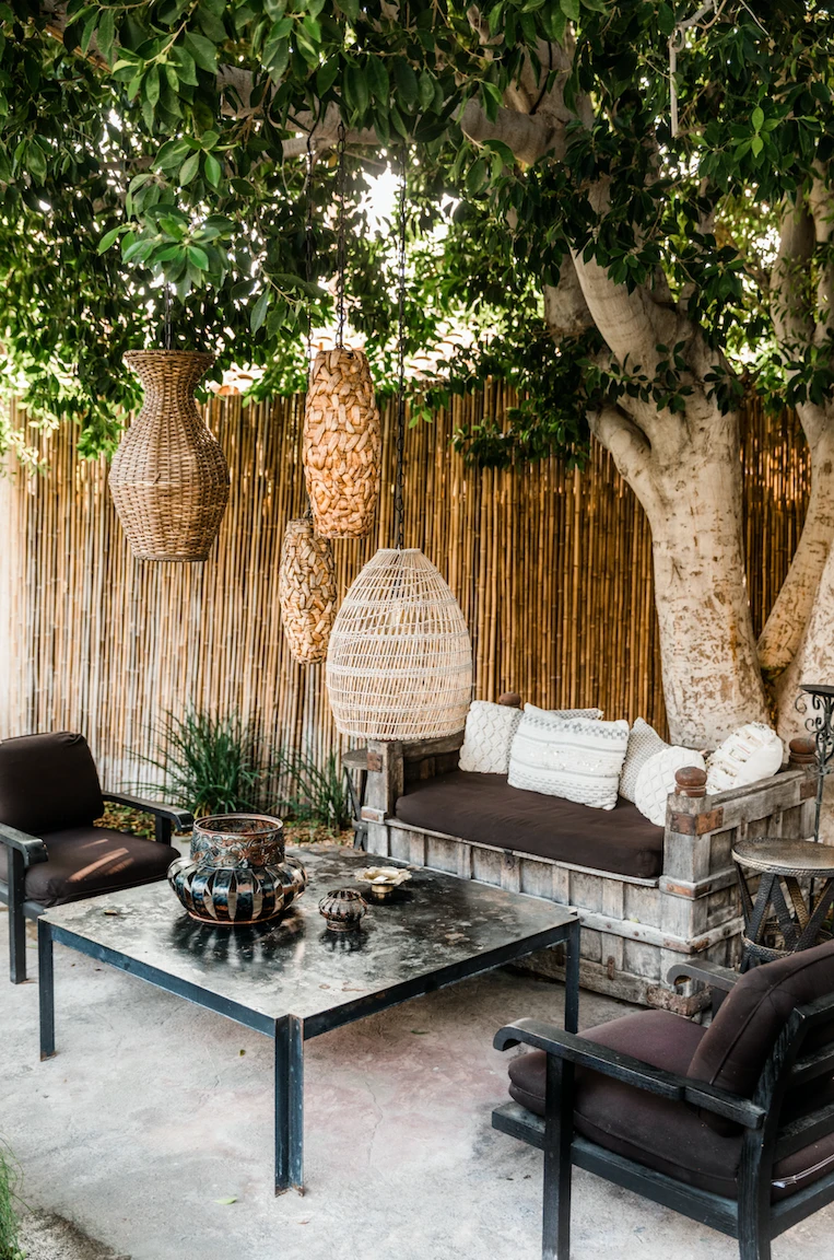 Lanterns hang from a tree above a patio at Talavera Palm Springs