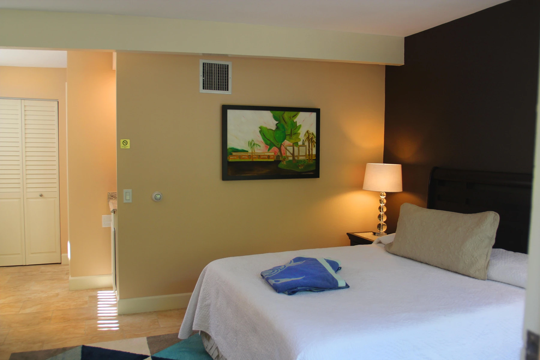 A bedroom at the Triangle Inn Palm Springs with original artwork on the wall