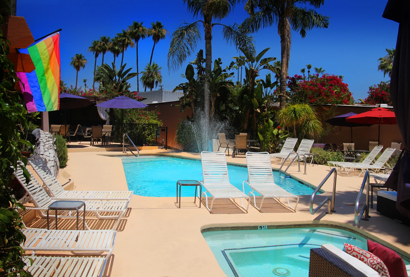 A rainbow flag hangs by the pool and spa at Triangle Inn Palm Springs, a men's clothing-optional resort in Palm Springs, California