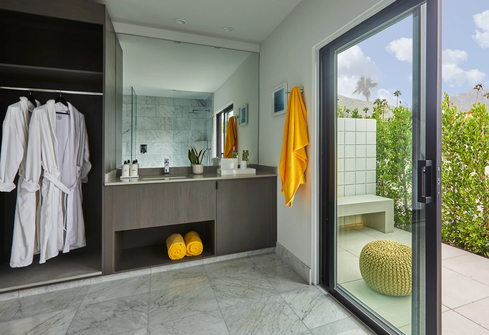 A large bathroom at Twin Palms Resort, a men's clothing-optional boutique hotel in Palm Springs, California, opens up to an outdoor patio