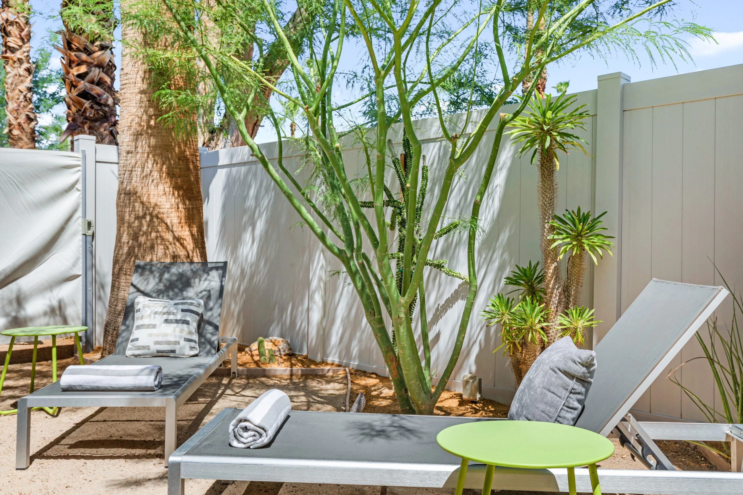 Two lounge chairs in the private patio of a room at The Weekend Palm Springs
