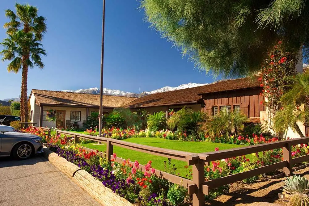 Flowers brighten up the lawn in front of a building at Smoke Tree Ranch