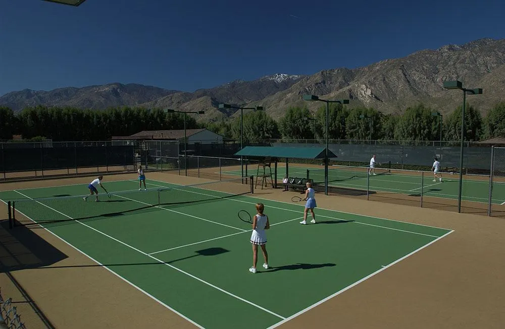 Two couples play tennis on a court at the Smoke Tree Ranch in Palm Springs, California
