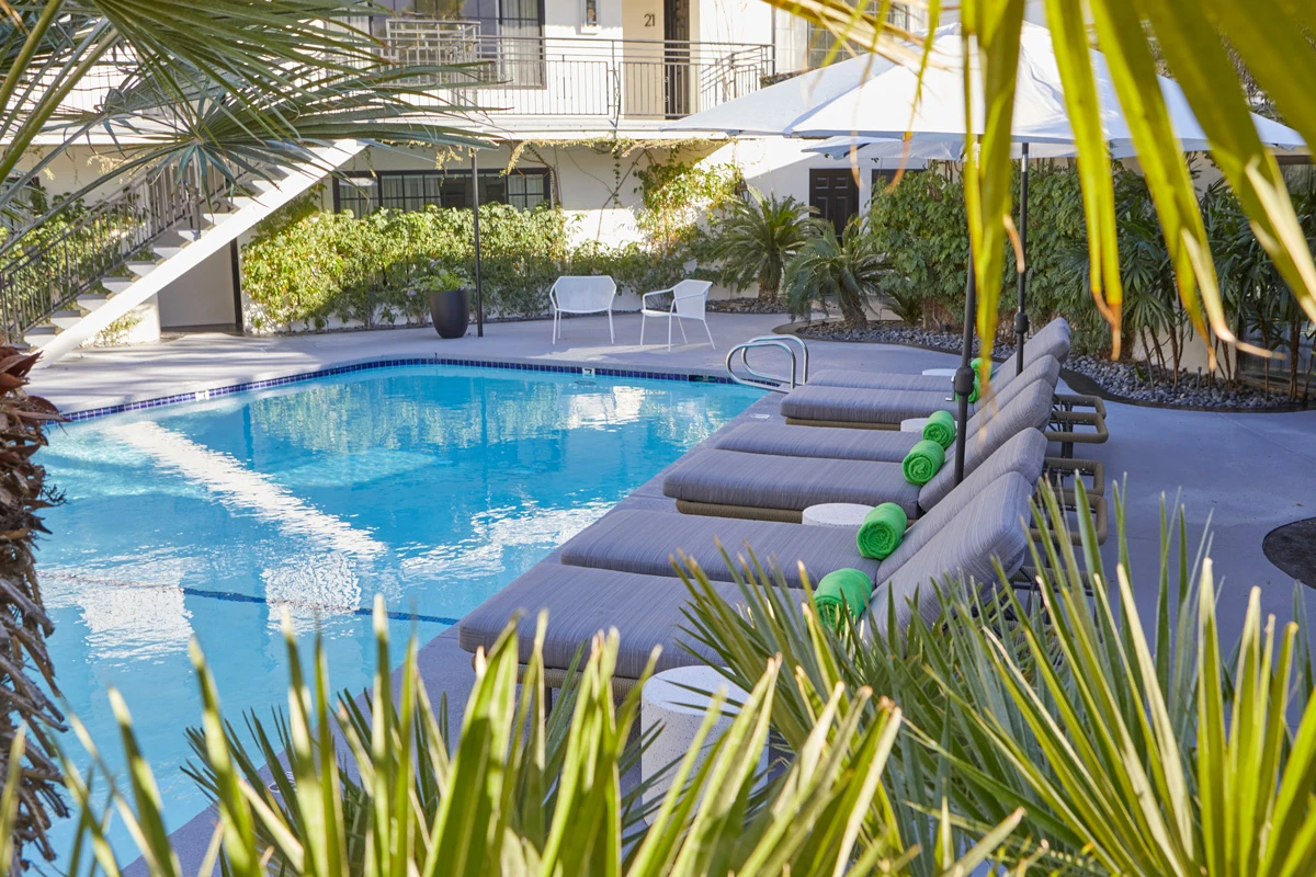 Gray lounge chairs in a row along the side of the gorgeous pool at Descanso Resort in Palm Springs, California