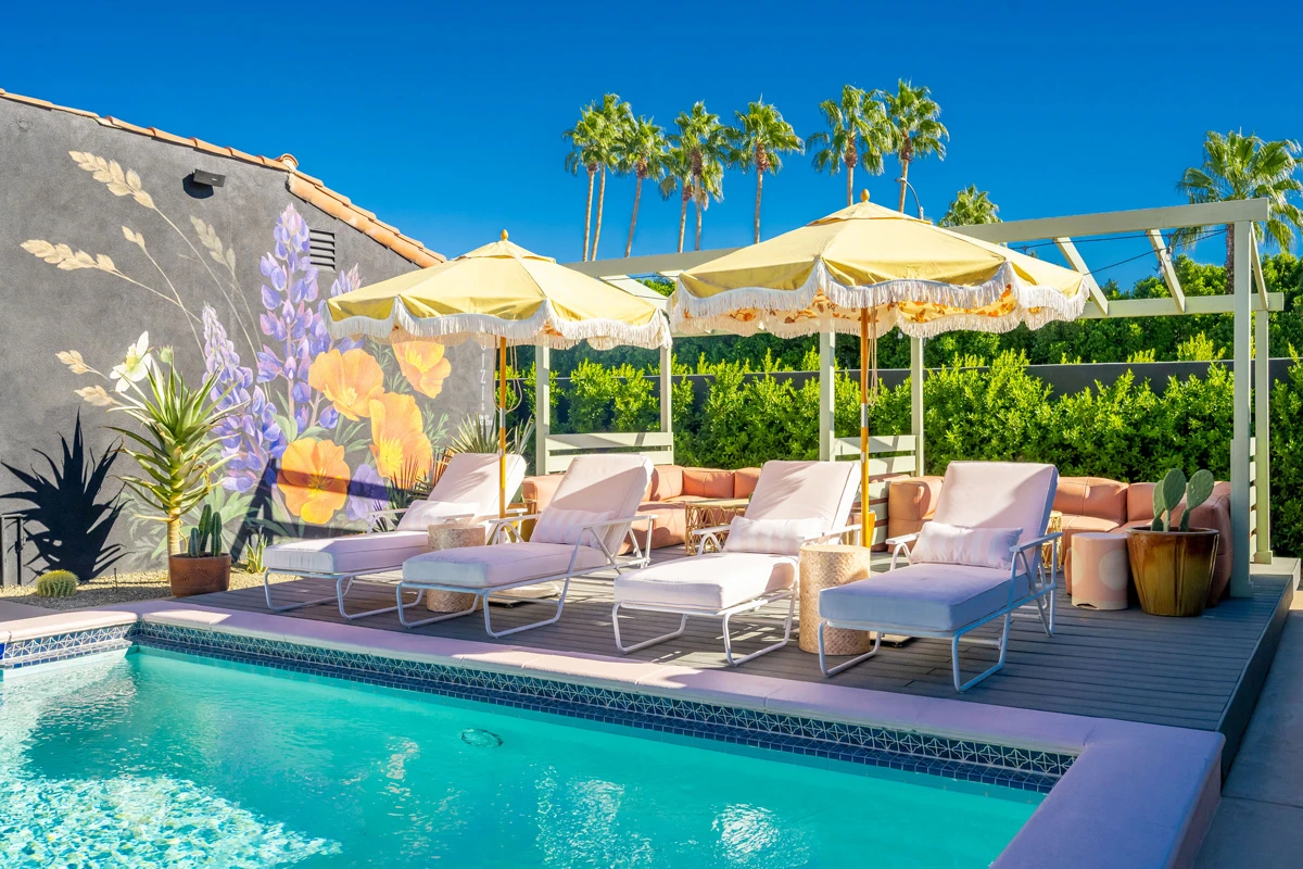 Fringed umbrellas surround the pool at Fleur Noire Hotel in Palm Springs, California