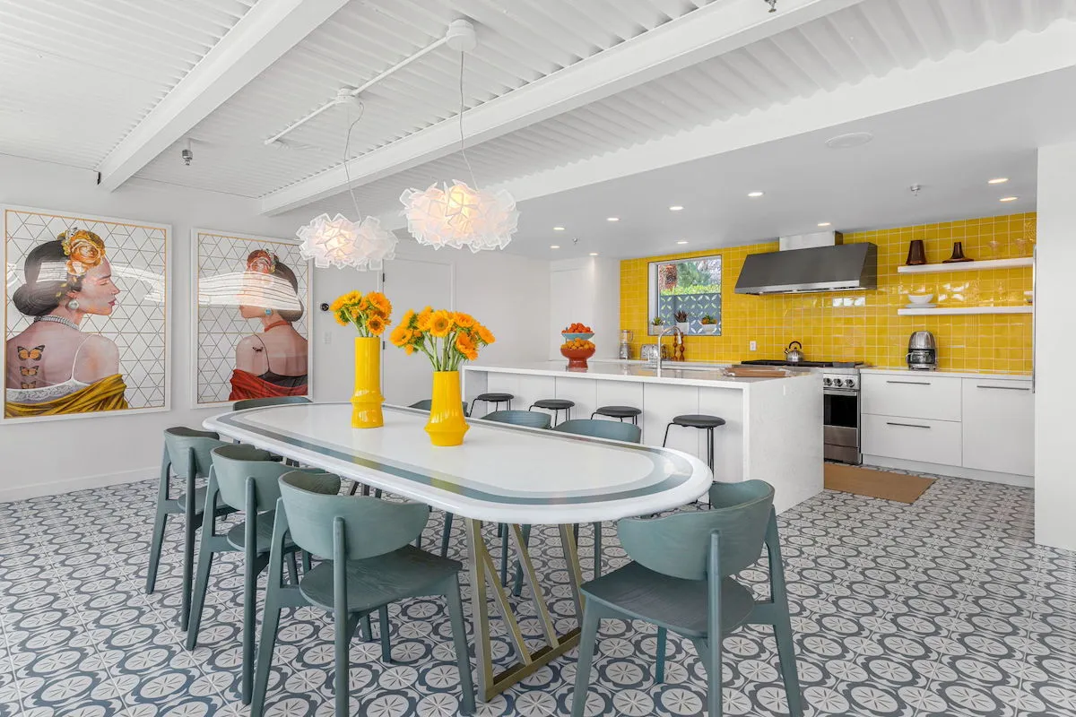 The kitchen at Limón Palm Springs with yellow and white tile and a long table with chairs