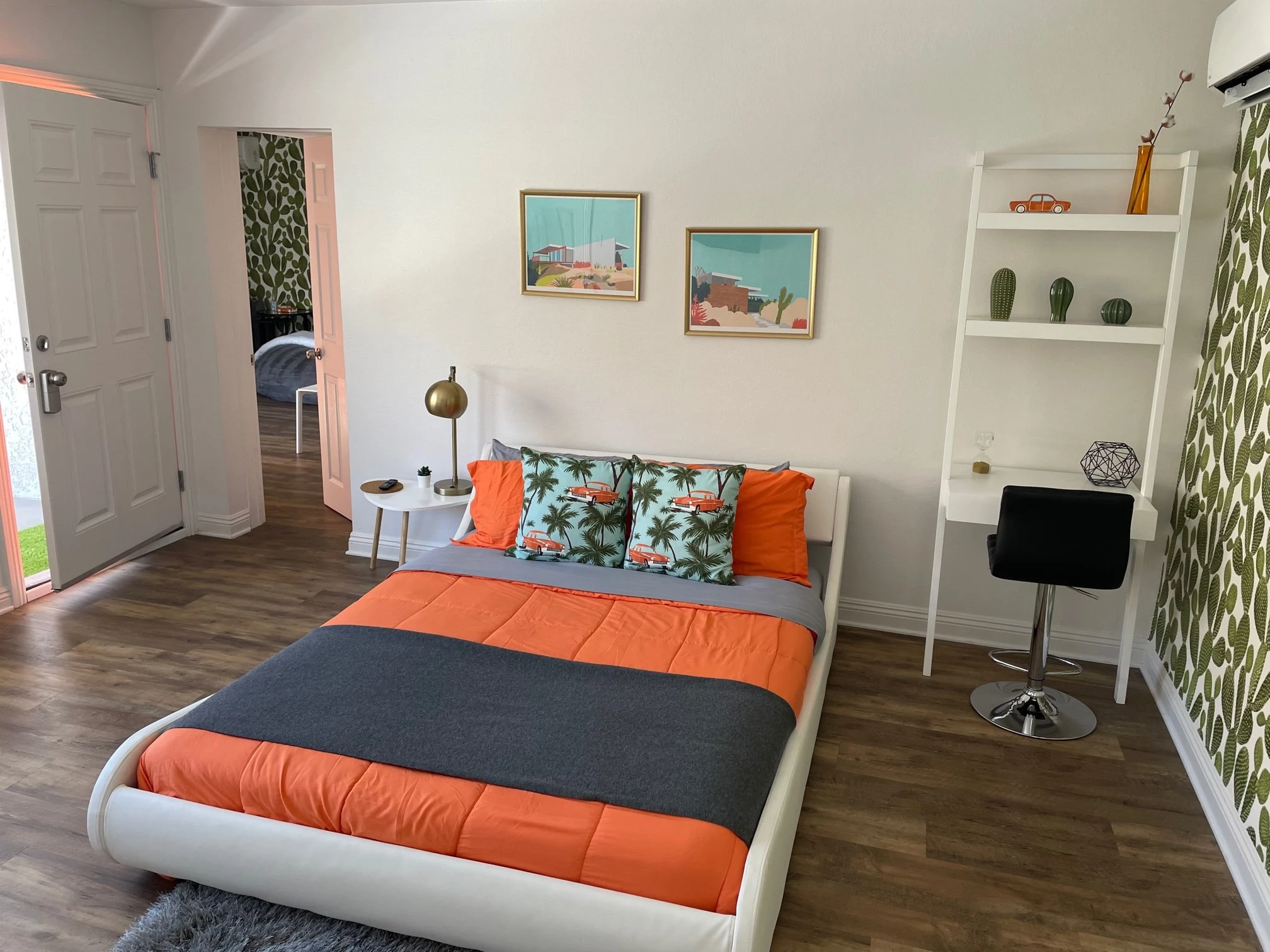 A platform bed with orange and black linens in a spacious room at The Tree Ten Hotel in Palm Springs, California