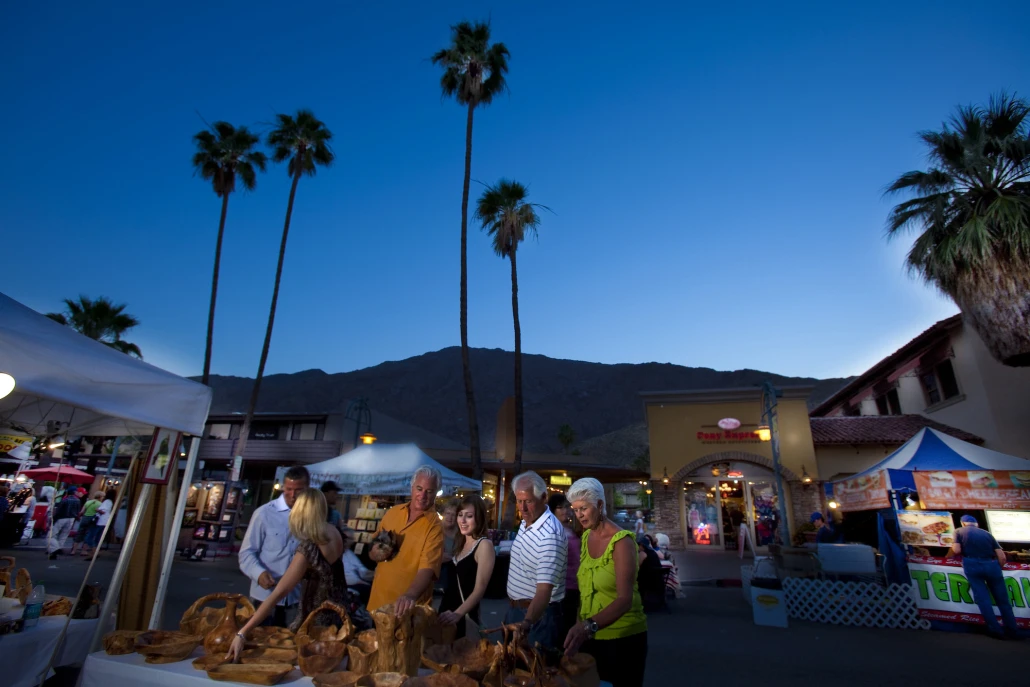 People look at items for sale as night falls over the Village Fest street fair in Palm Springs