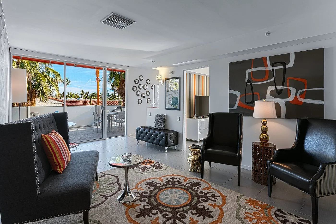 A mid-century modern furnished room with black and orange accents at The Twist Palm Springs boutique hotel