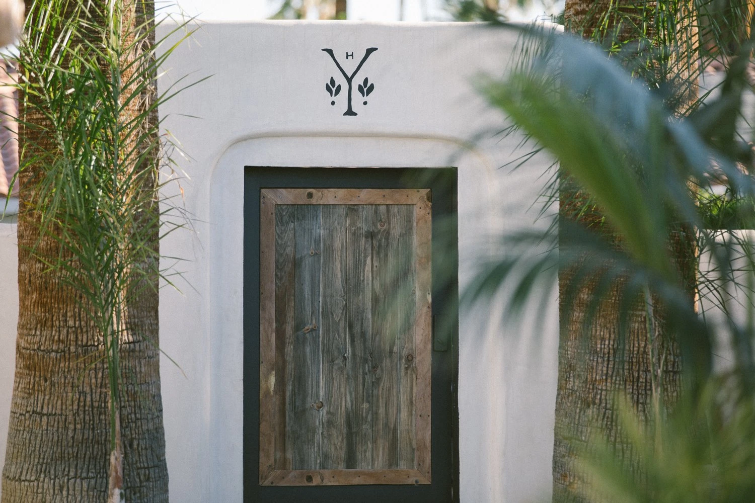 A wooden door leads to a guest room at Yara Hotel in Palm Springs, California