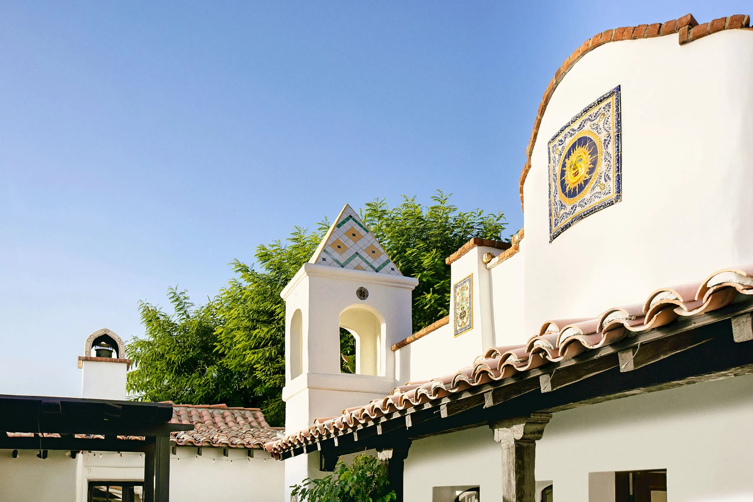 The exterior of The Lucille Palm Springs with a tile of the sun and red tile roof
