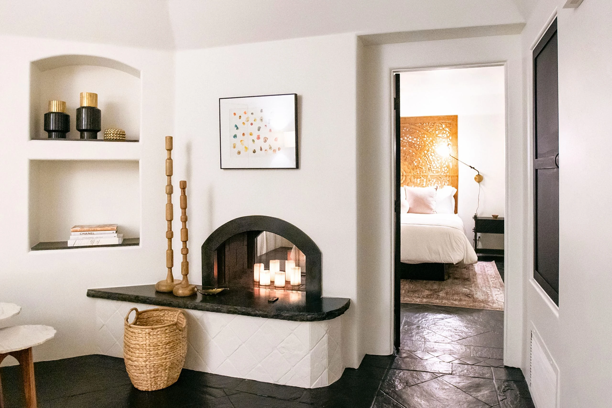 The open fireplace with candles in it inside the living room area of a villa at The Lucille Palm Springs