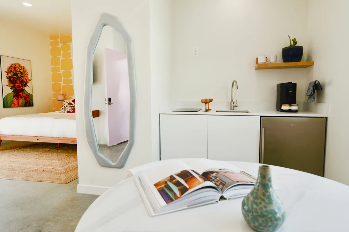A kitchen at The Cactai in Palm Springs with a sink and white table with an open book on it