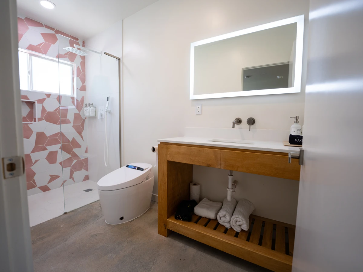 A white Japanese toilet inside a bathroom at The Cactai