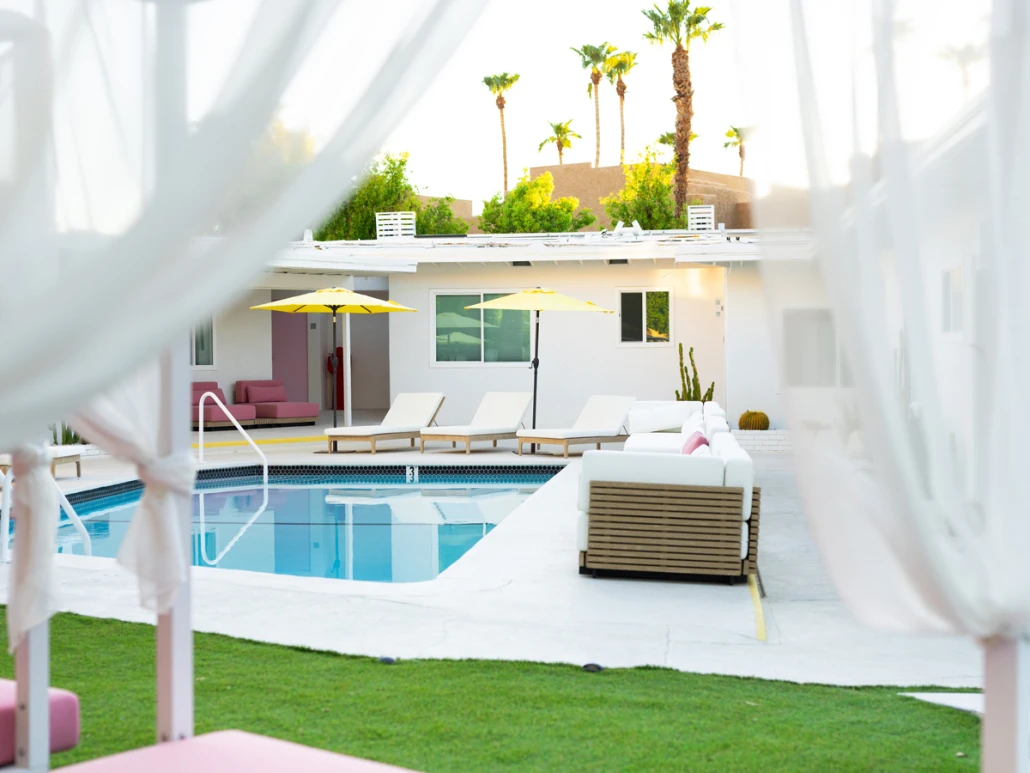 The pool at The Cactai in Palm Springs surrounded by cabanas and palm trees