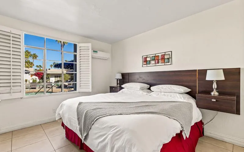 A crisp white bedspread covers a bed at Casa Oliver
