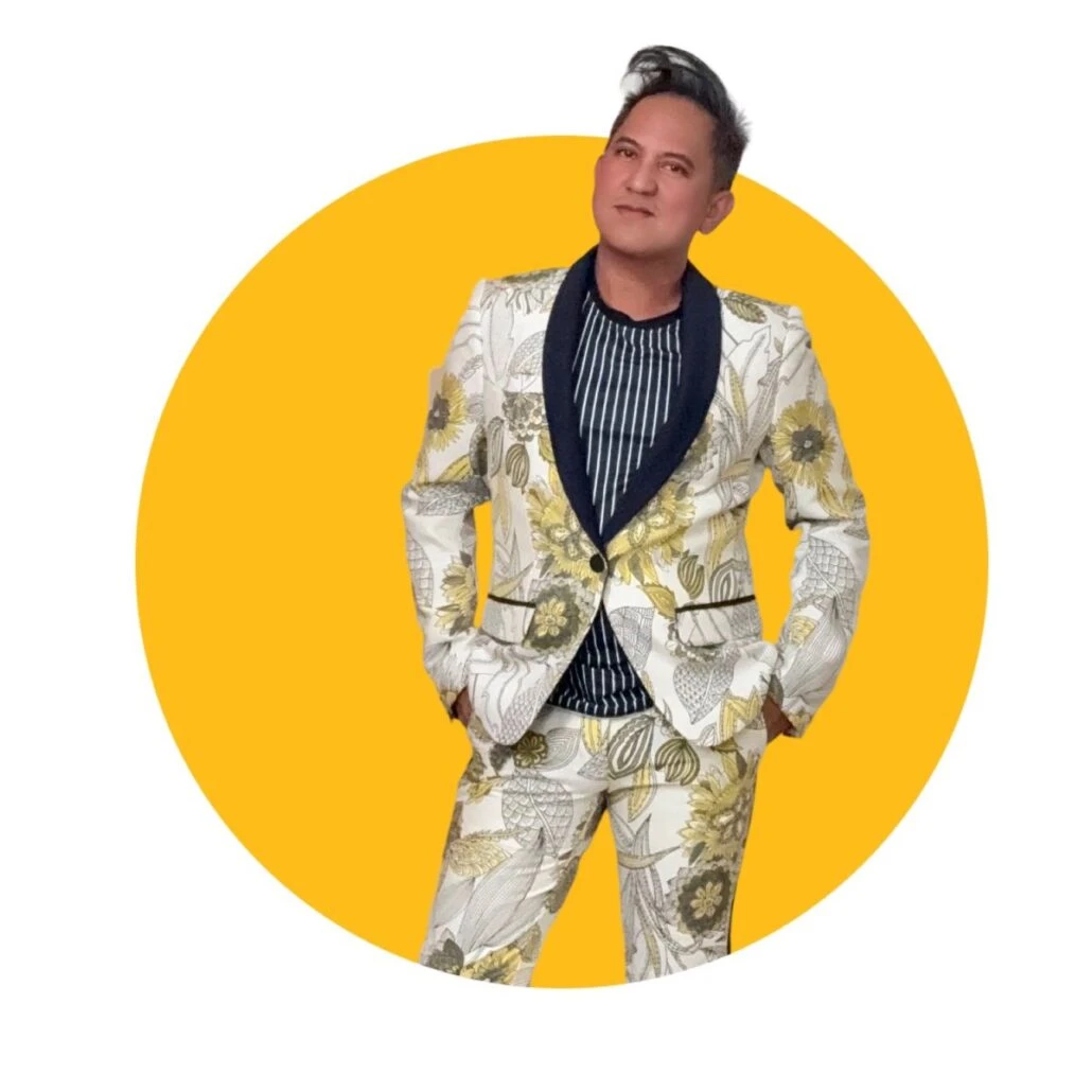 A man with black hair wears a patterned suit