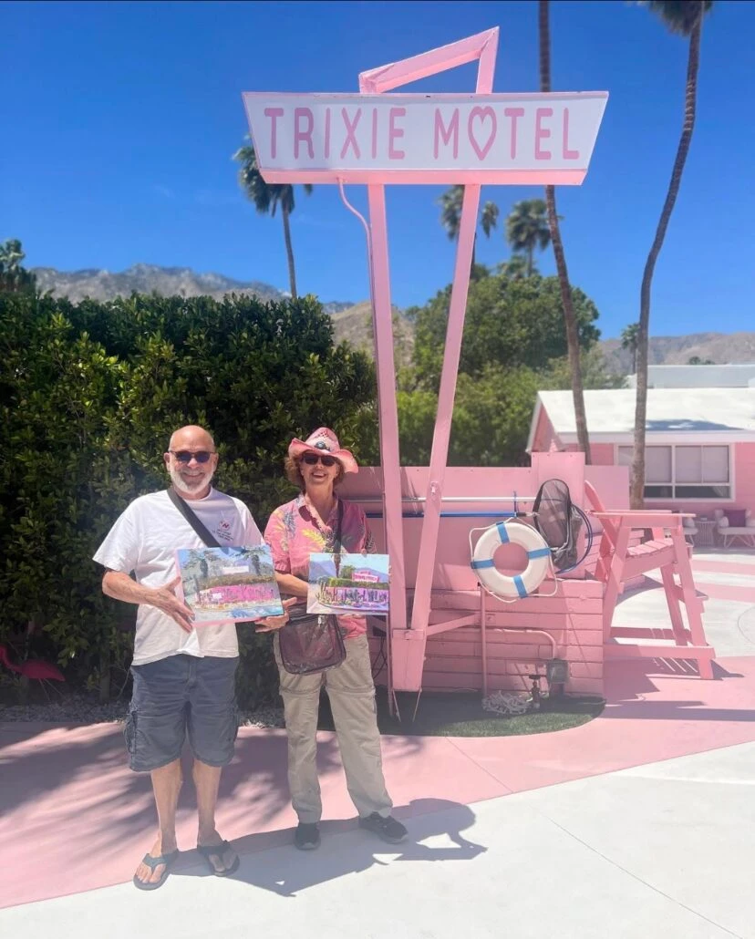 A man and a woman hold their paintings out at The Trixie Motel